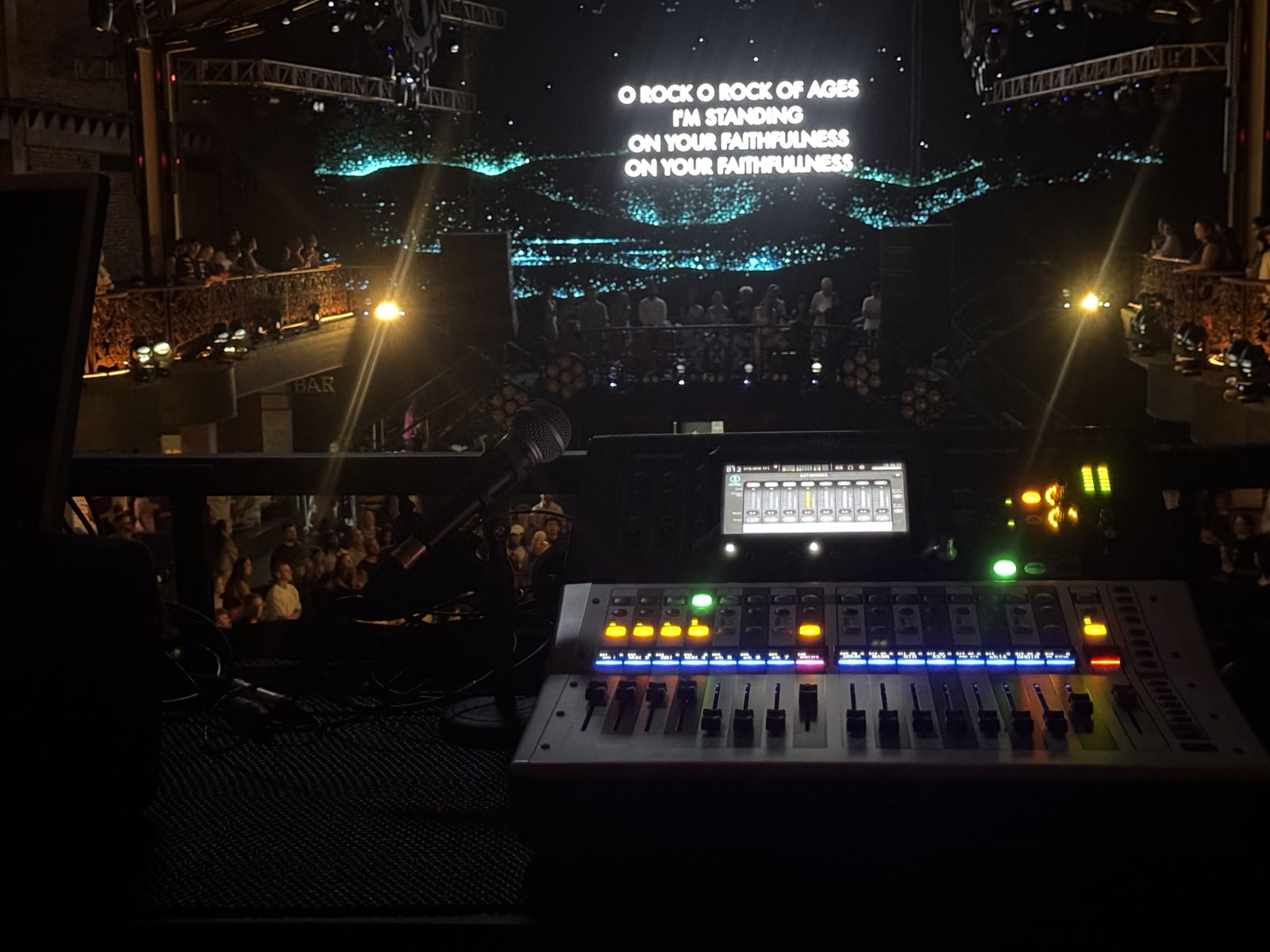 Mixing desk at a church service, lyrics on the screen