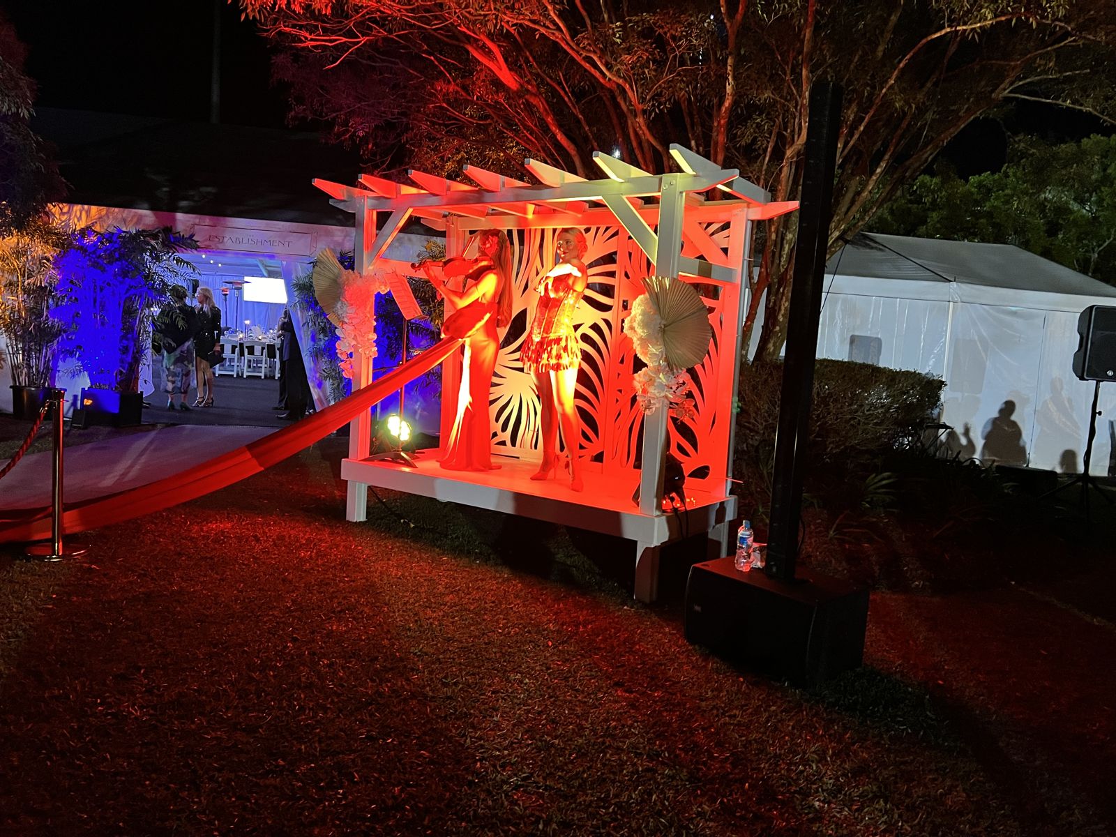 Pergola lit red at night for an activation at Corbould Park