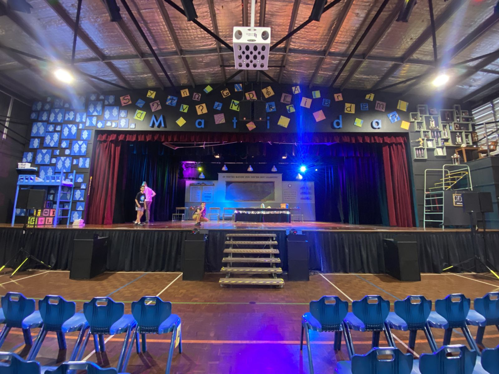 School hall stage lit for a production of Matilda